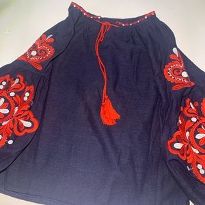 Navy blue shirt with red embroidery on it